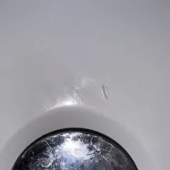 Mała dziura w wannie akrylowej, która wymaga naprawy. Dowiedz się, jak naprawić dziurę w wannie akrylowej.