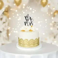 Elegancki tort weselny z napisem "Mr & Mrs" i złotymi zdobieniami. Idealne miejsce, gdzie kupić ozdoby na tort na wyjątkowe okazje.