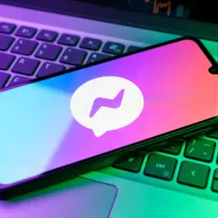 Smartfon z logo Messengera na klawiaturze laptopa. Chcesz wiedzieć, jak zrobic aktualizacje Messengera?