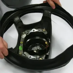 Pokazana instrukcja jak obszyć kierownicę. Dłonie naciągają czarną skórę na obręcz kierownicy z widocznym mechanizmem poduszki powietrznej.
