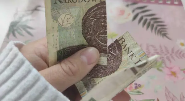 Dłoń trzyma sklejony banknot 10 zł. Zastanawiasz się, co zrobić ze sklejonym banknotem?