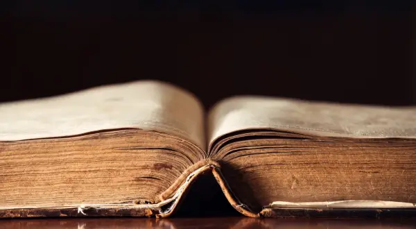 Stary, pożółkły tom księgi otwarty na środku, przypominający o tym, kiedy powstał Stary Testament.