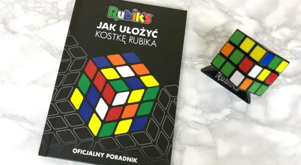 Książka "Jak ułożyć kostkę Rubika" i kostka Rubika na podstawce. Oficjalny poradnik dla początkujących.