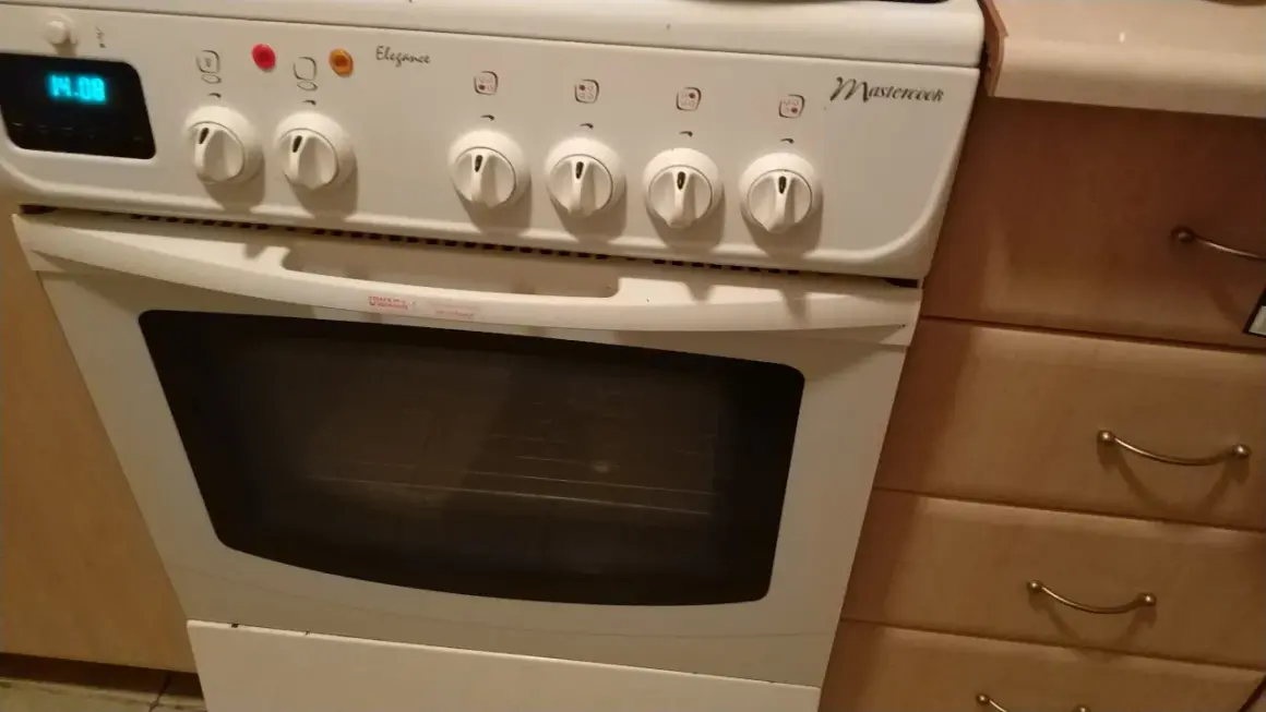 Biały piekarnik Mastercook z cyfrowym wyświetlaczem 14.08. Pokrętła i lampka kontrolna. Instrukcja obsługi jest dostępna.
