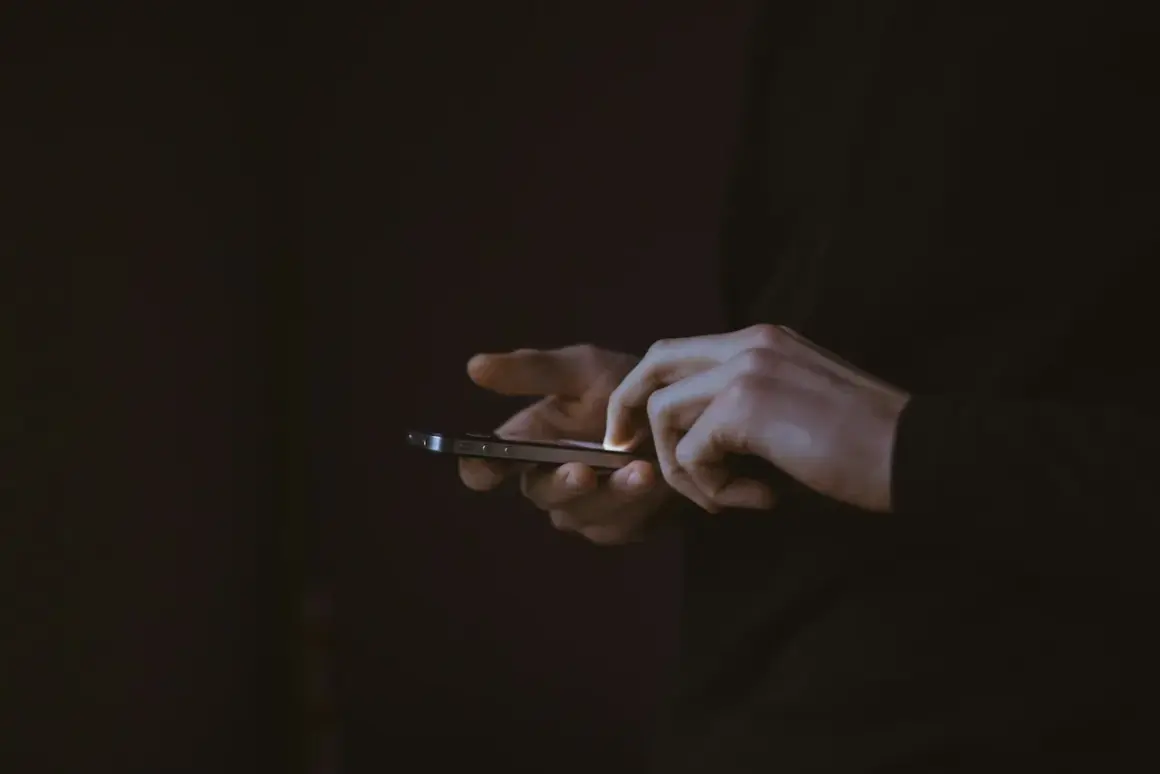 Dłonie użytkownika na ekranie smartfona, być może szukającego informacji, jak zrestartować Messengera.