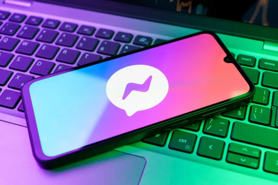 Smartfon z logo Messengera na klawiaturze laptopa. Chcesz wiedzieć, jak zrobic aktualizacje Messengera?