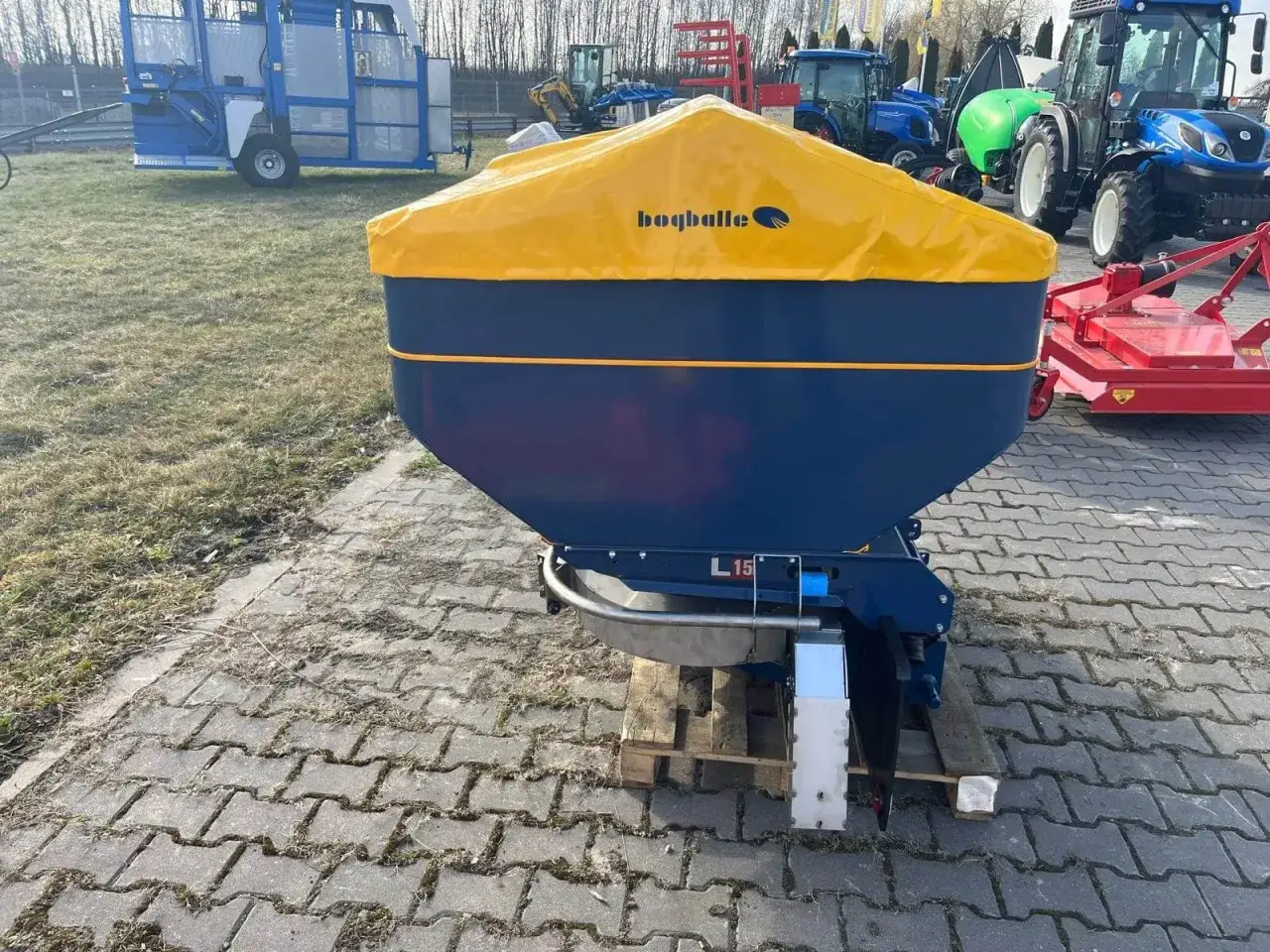 Siewnik Bogballe L15 z żółtą plandeką, gotowy do pracy. Tabela wysiewu pomoże dobrać odpowiednie ustawienia.